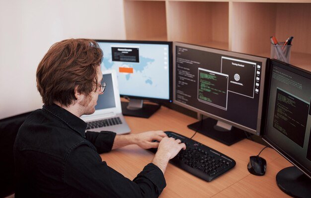 Offerings male-programmer-working-desktop-computer-with-many-monitors-office-software-develop-company-website-design-programming-coding-technologies-1040180-7096
